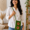 Handmade Green Crochet Phone Pouch Young woman wearing a handmade green crochet phone pouch with floral accents as a crossbody sling.